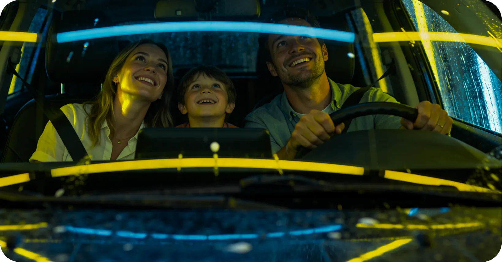 Família dentro do carro durante uma lavagem automatizada com luzes coloridas